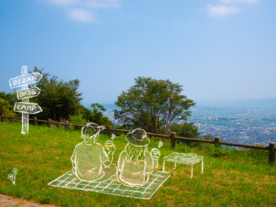 展望広場でピクニックする様子と BIZAN BASE CAMP の道標